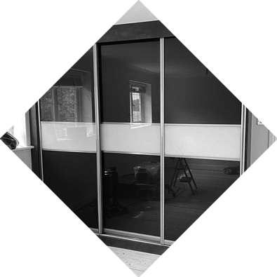 Built-in sliding glass wardrobe with reflective panels, perfect for modern homes or showroom spaces.